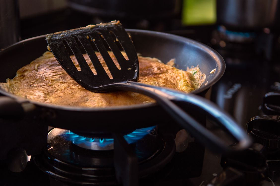 Perfectly cooked omelette in a nonstick frying pan with spatula