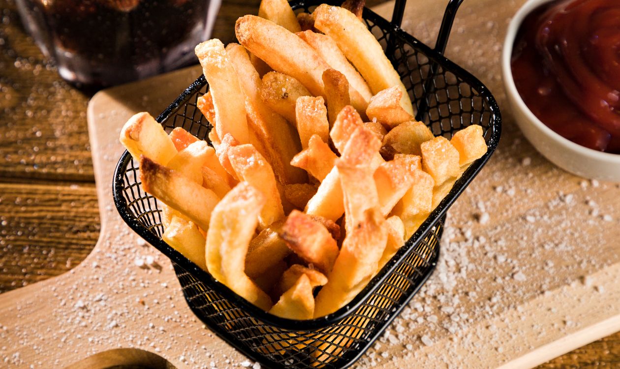 Crispy French fries in an air fryer basket