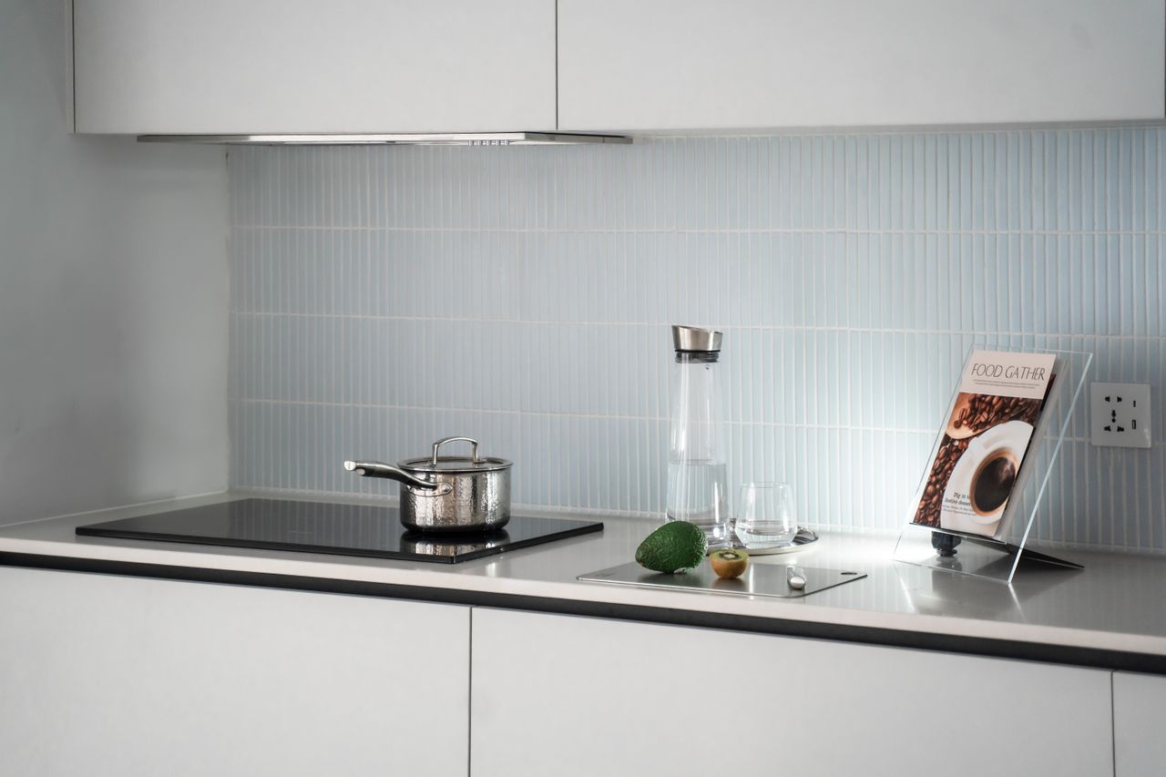 A stainless steel pot on a black glass induction cooktop