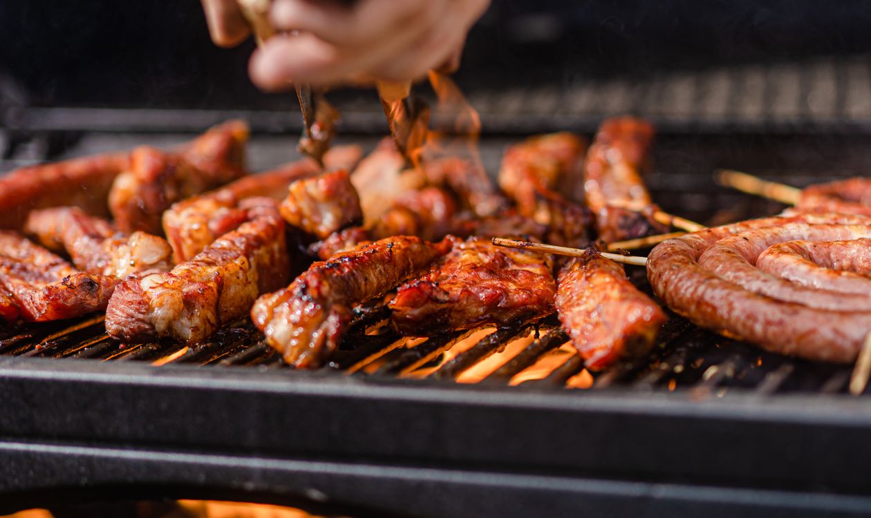 Meat skewers grilling over an open flame
