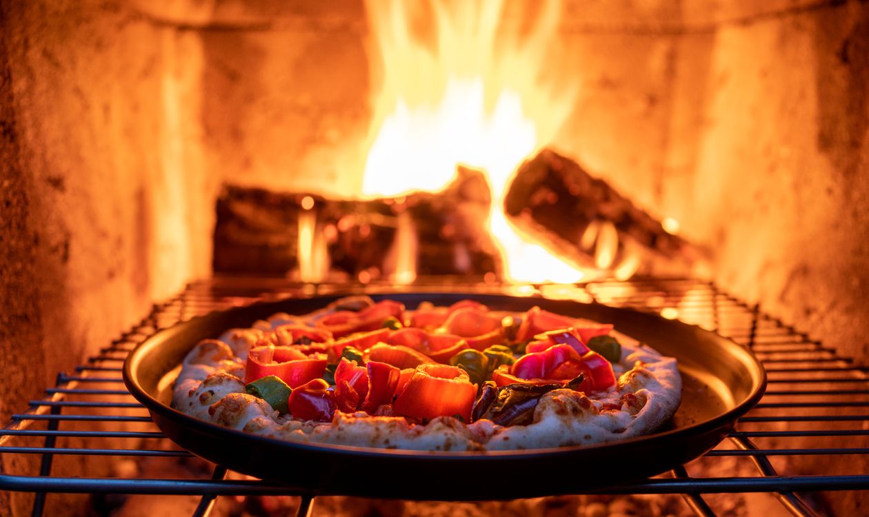 Pizza baking in a hot outdoor oven